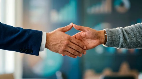 Professional photograph showing hands in collaborative gesture representing data trust exchange between business and customer